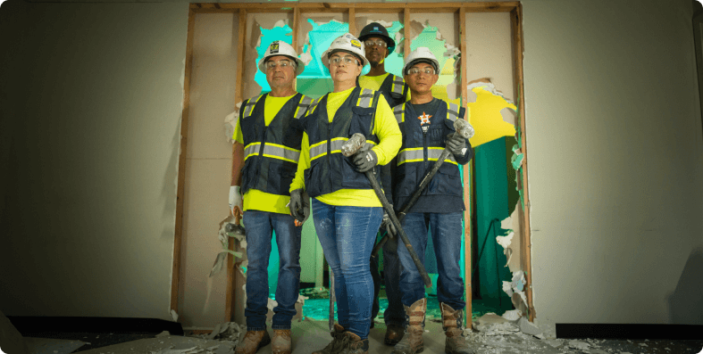 Demolition crew in front of a wrecked wall