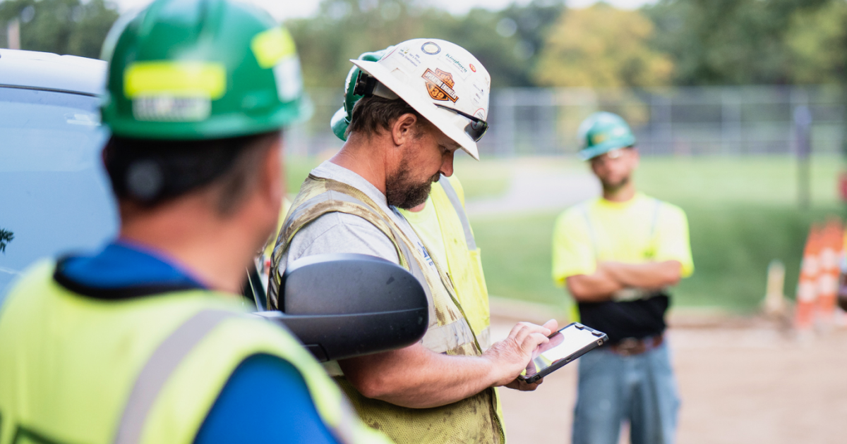 Field supervisor checking plans with crew members