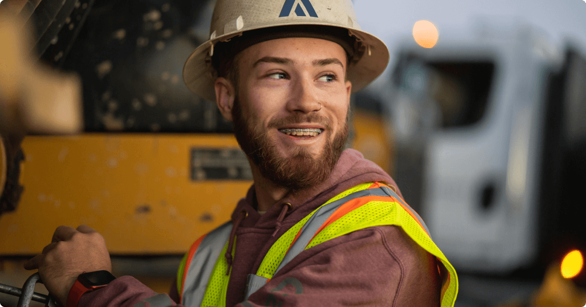 Dirt World worker looking over his shoulder and smiling