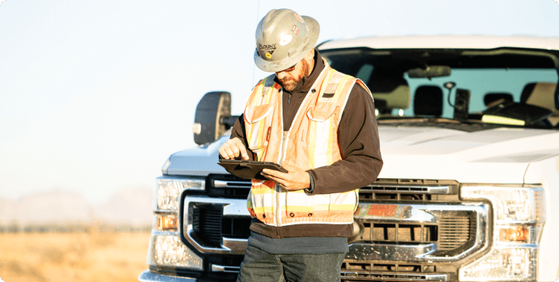 Construction leader leaning on his truck